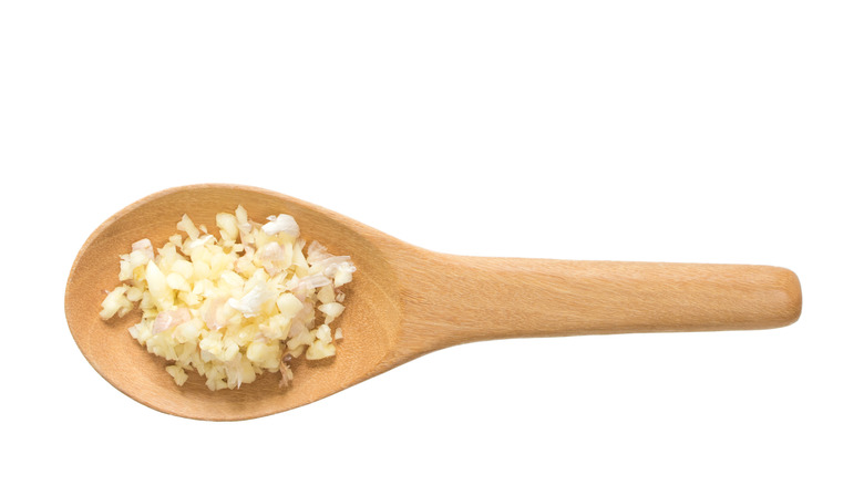 Chopped garlic on a wooden spoon