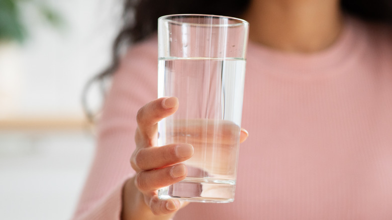Hand holding glass of water