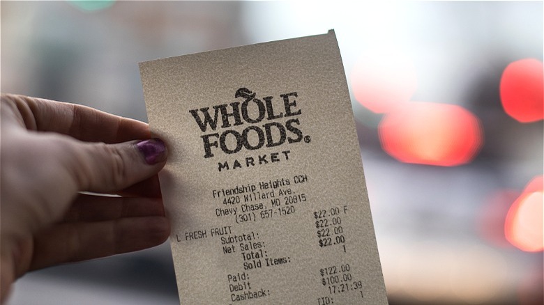 Hand holding Whole Foods receipt 