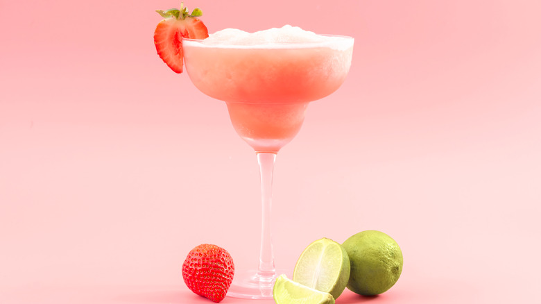 A frozen strawberry margarita in a margarita glass.