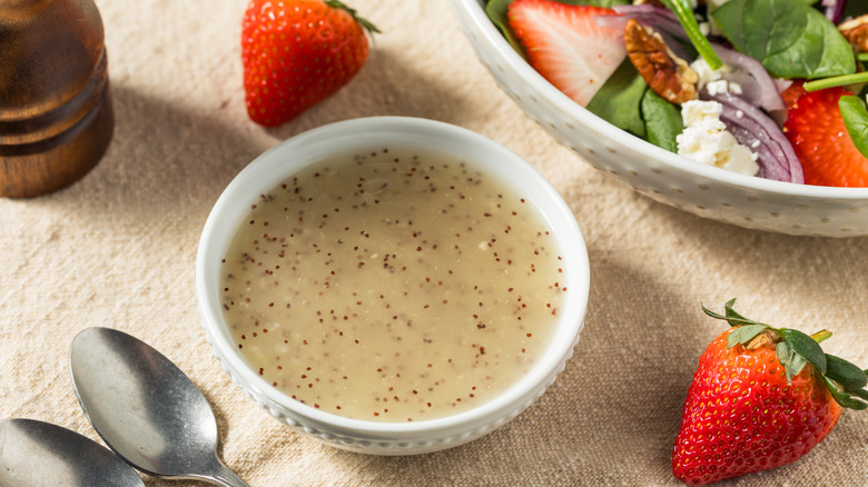 Bowl of salad dressing next to salad