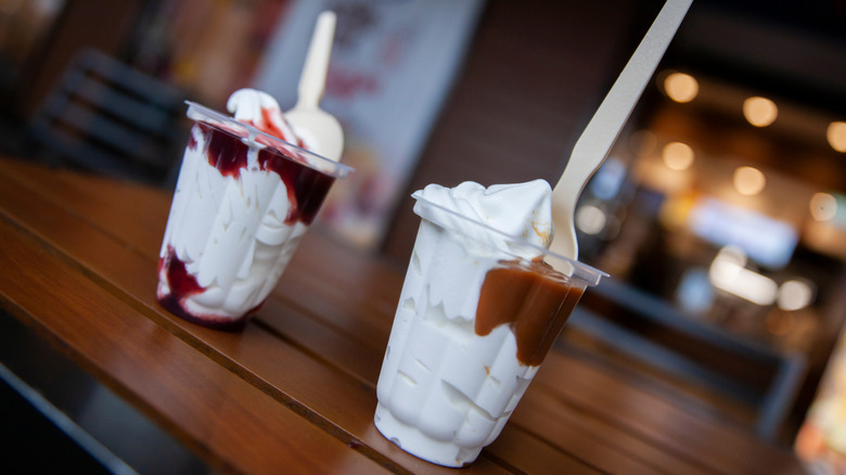 two Burger King soft serve ice cream sundaes in cups with spoons