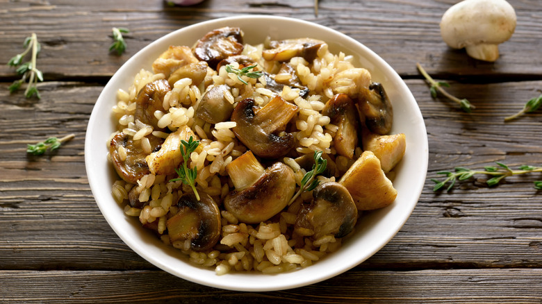 mushroom risotto in bowl on wood table