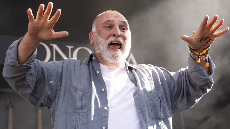 Chef José Andrés in a white T-shirt and open button-down light blue shirt with his hands up while speaking.