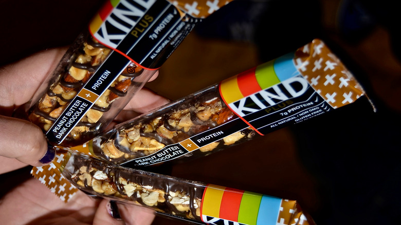 A person holds three KIND bars