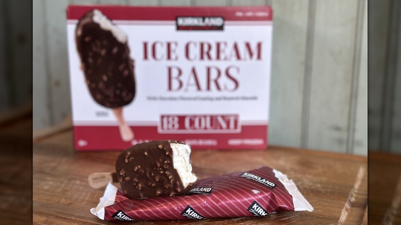 A kirkland ice cream bar with a bite taken out, exposing the vanilla ice cream inside