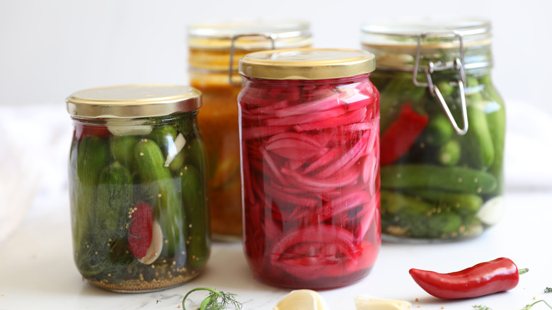 pickles and pickled red onions in glass jars