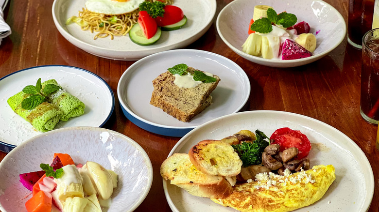 Assorted brunch dishes on white plates on a table