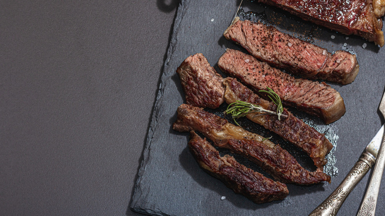 Slices of well-done steak on a granite surface