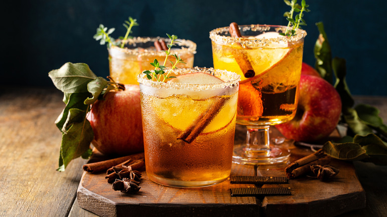 Apple cider margaritas with brown sugar rims, apple slices, and cinnamon sticks