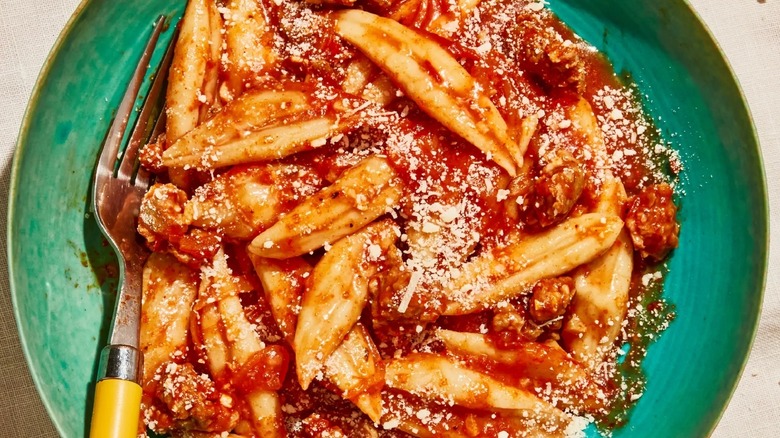 scissor-cut noodles in red sauce on green plate