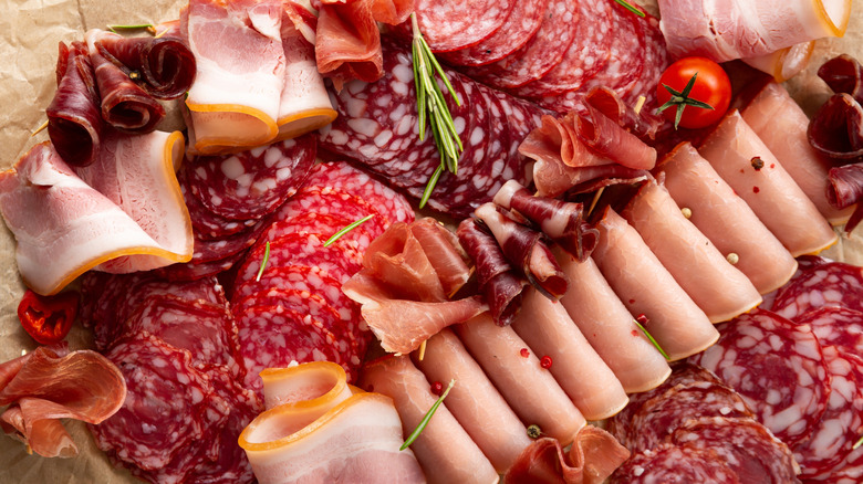 Close up of deli tray with meat, cheeses, olives, tomato and lettuce