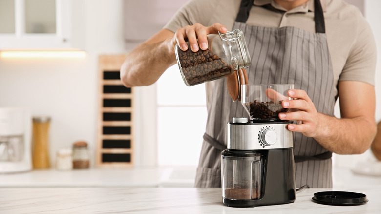 man using electric coffee grinder