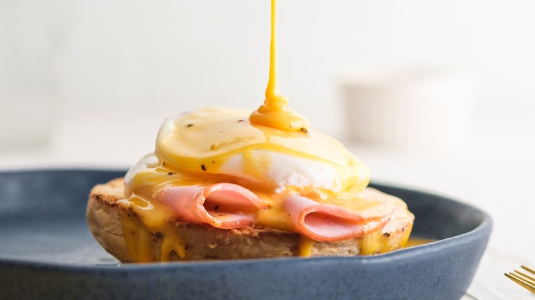 Hollandaise sauce poured over eggs