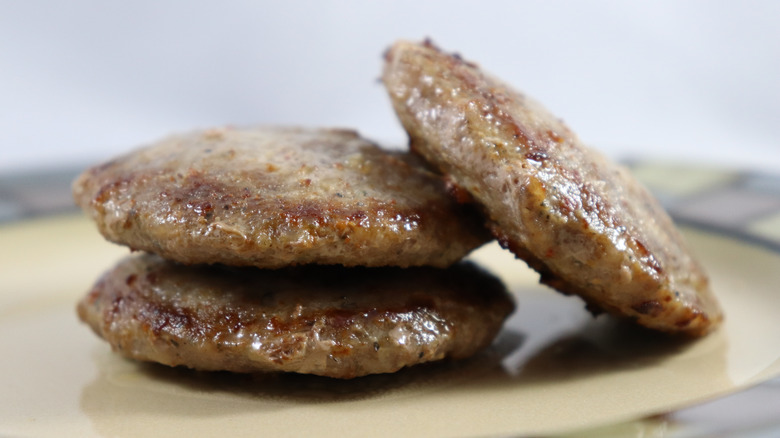 three breakfast sausage patties served on plate
