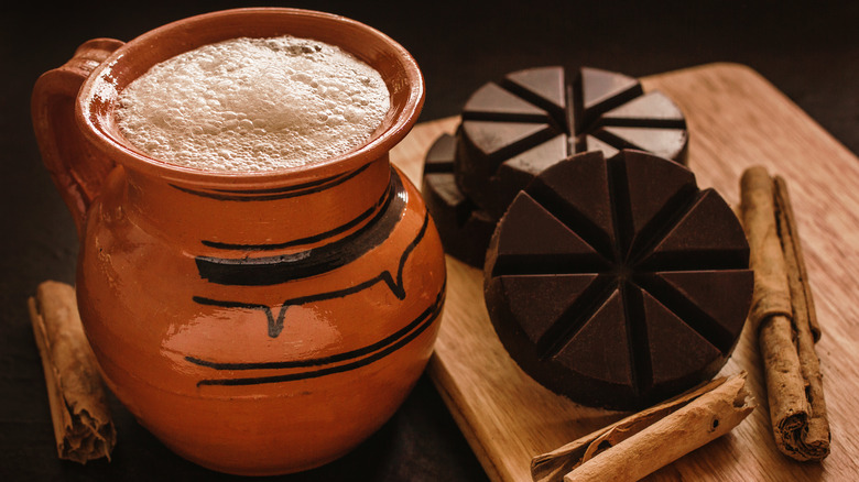 Mexican hot chocolate with cinnamon sticks on the side