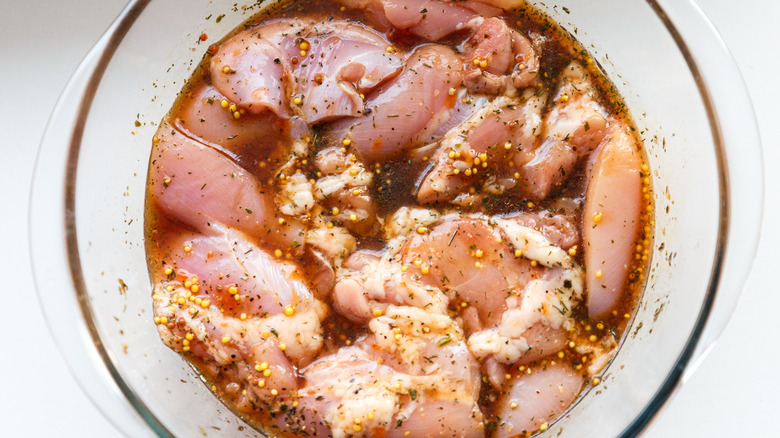 Raw chicken in marinade bowl
