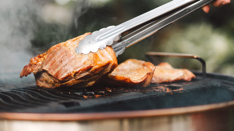 turning marinated chicken on grill