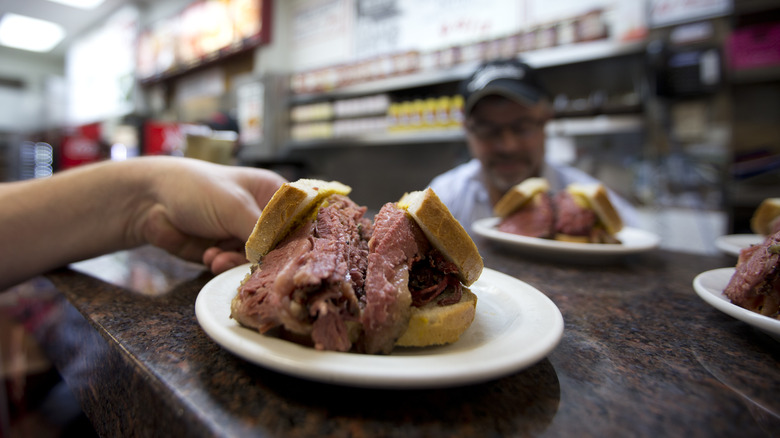 A waiter grabbing Montreal smoked meat