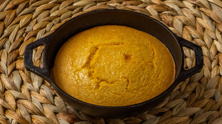 Spider cake in a cast iron skillet atop a braided basket