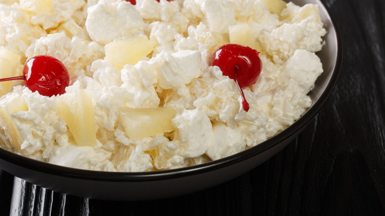 black bowl of glorified rice garnished with maraschino cherries