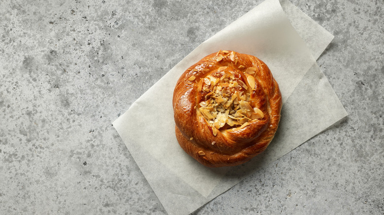 Dakota roll topped with almonds on white tissue paper
