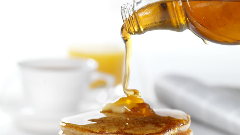 pouring maple syrup on pancakes