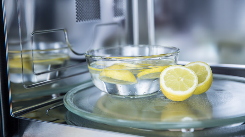 Bowl of water with lemons in microwave