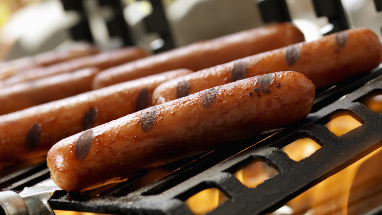 Hot dogs with grill marks over a flame