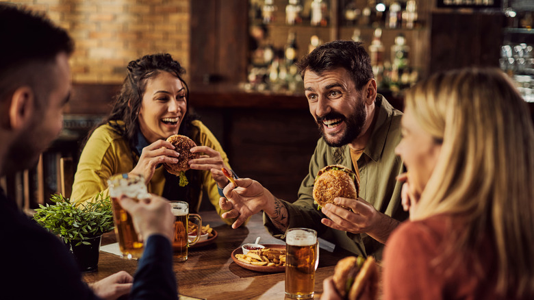 friends eating burgers and drinking beers