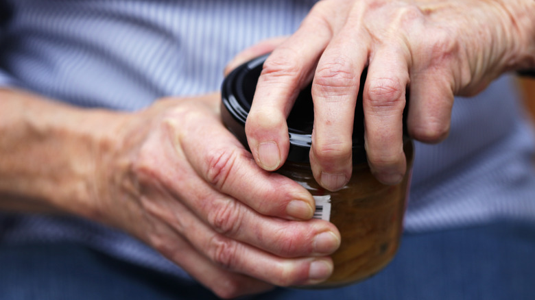 Hands opening a jar