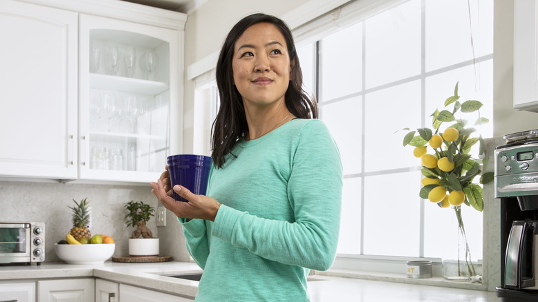 person enjoying coffee in a kitchen