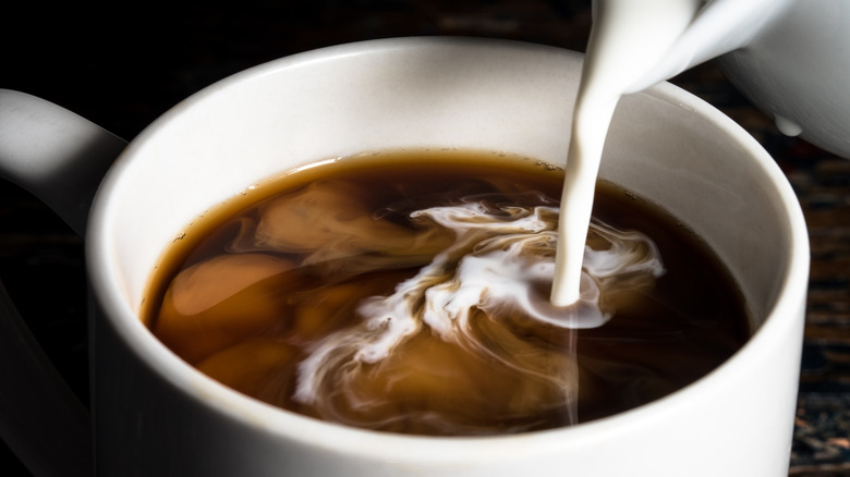 pouring creamer in coffee