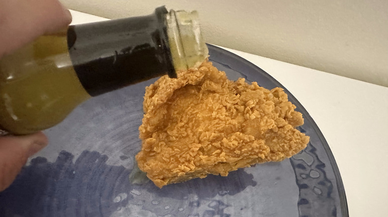 pouring hot sauce on chicken