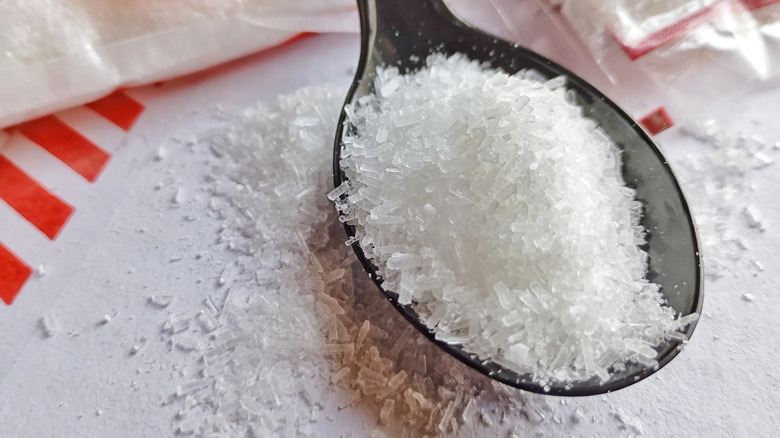 A closeup of MSG in a plastic spoon