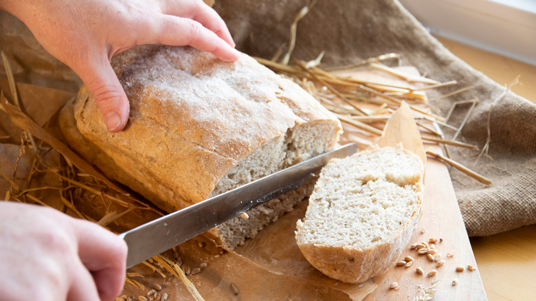 A dense loaf of bread cut with a bread knife