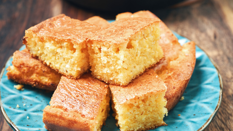 Squares of cornbread on a blue plate.