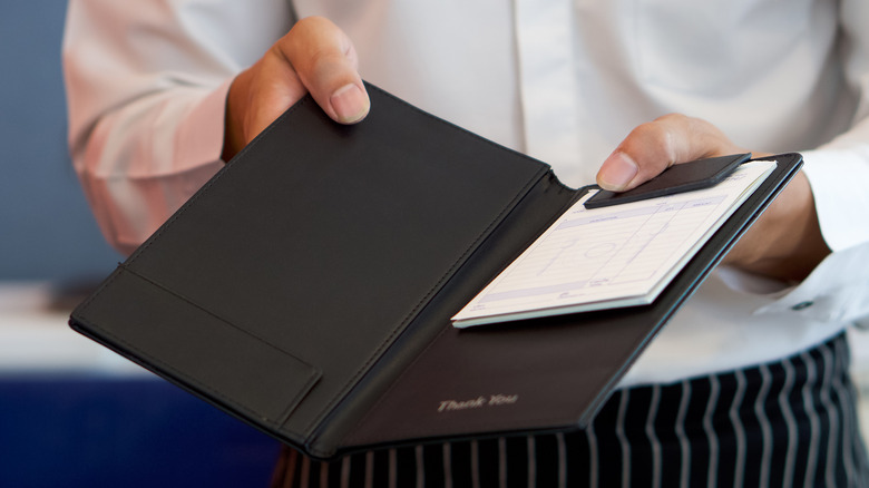 Waiter holding dining check