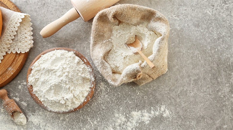 Flour in wooden bowl and sack
