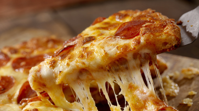 lifting slice of pepperoni pizza