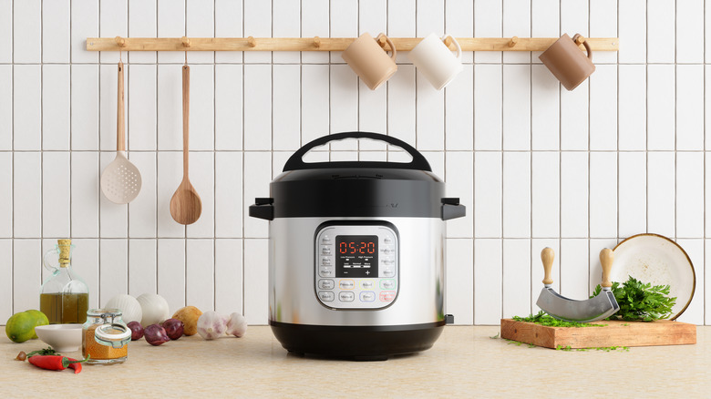 Slow cooker on a counter with food and spices