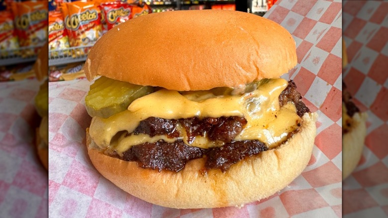 An NFA burger with two smashed patties and cheese slices, pickles, and a bun