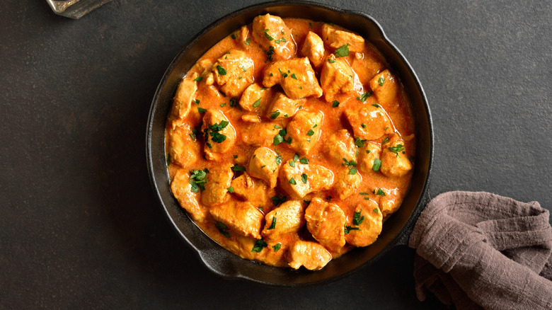 Chicken cubes and orange sauce in cast iron pan