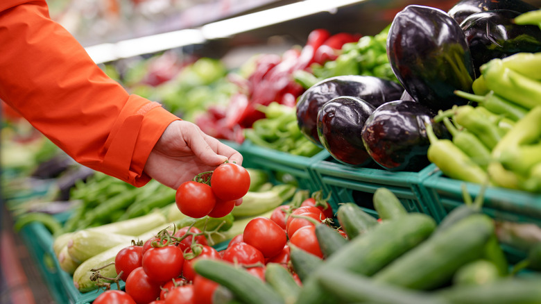 Shopper grabbing tomatoes 