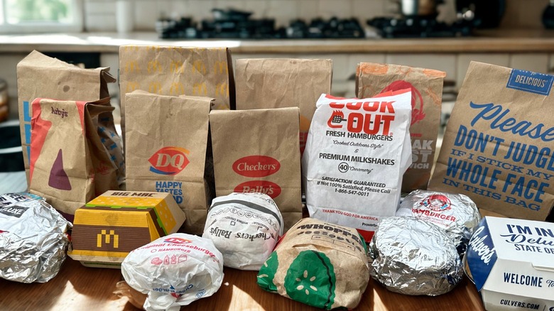 Variety of fast food chain takeout bags and wrapped signature burgers