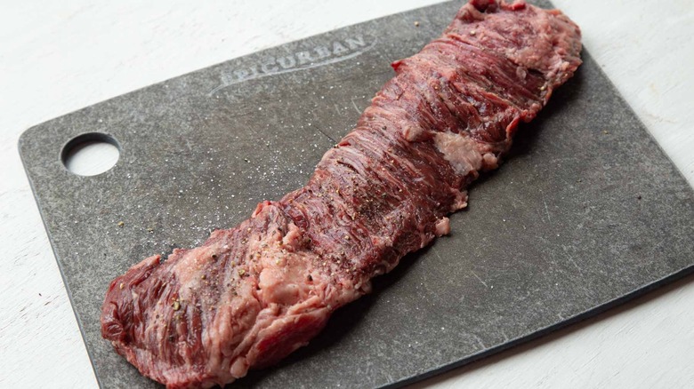 Seasoned skirt steak on cutting board