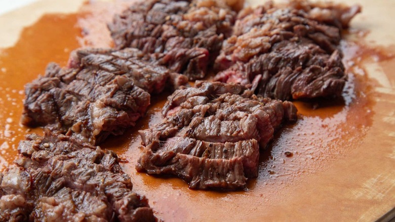 Sliced cooked steak on cutting board