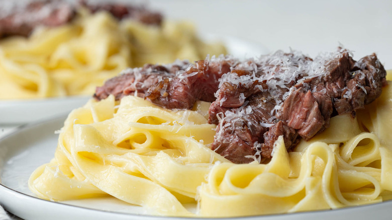 Side view of steak Alfredo pasta