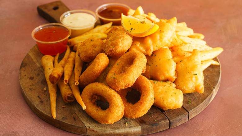 A platter of fried appetizers with dipping sauces