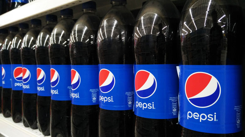A lineup of Pepsi bottles on a shelf